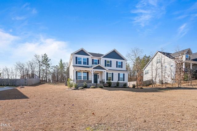 view of front of house with stone siding and fence