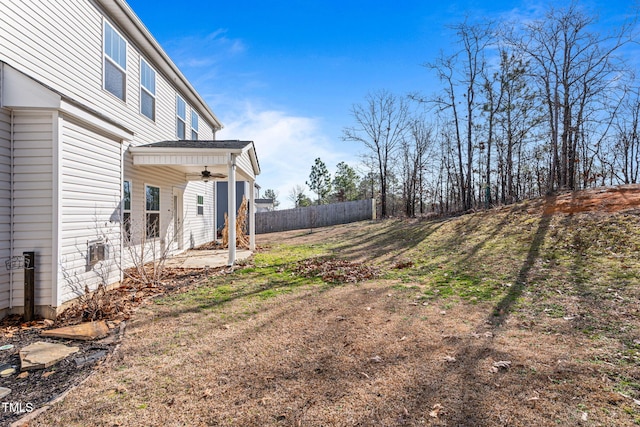 view of yard featuring a patio area, ceiling fan, and fence