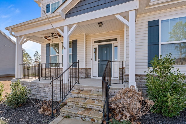 property entrance with a ceiling fan, stone siding, and a porch