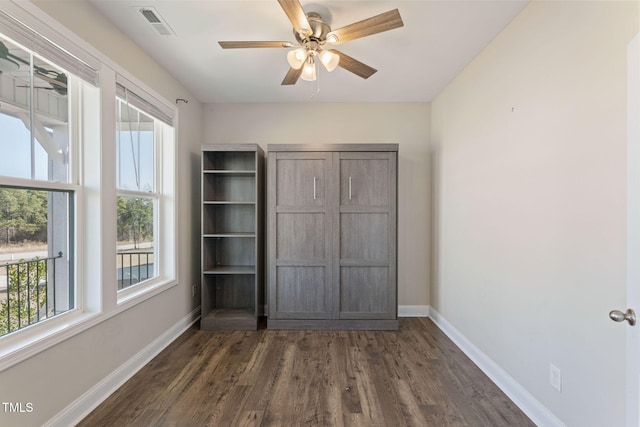 unfurnished bedroom featuring ceiling fan, dark wood finished floors, visible vents, and baseboards