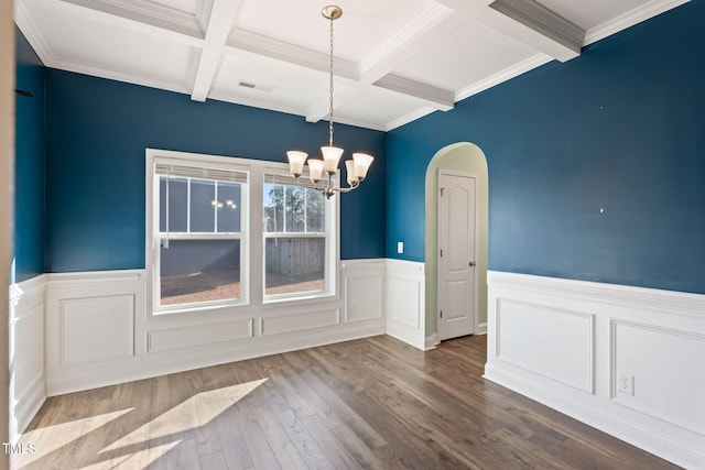 unfurnished dining area with arched walkways, wood finished floors, beam ceiling, and an inviting chandelier