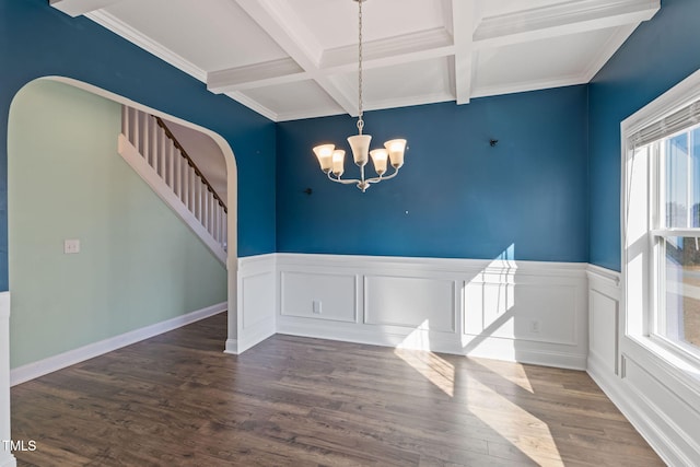 unfurnished dining area with arched walkways, dark wood-type flooring, beamed ceiling, stairs, and a notable chandelier