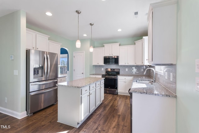 kitchen featuring stainless steel appliances, hanging light fixtures, white cabinets, a kitchen island, and a sink