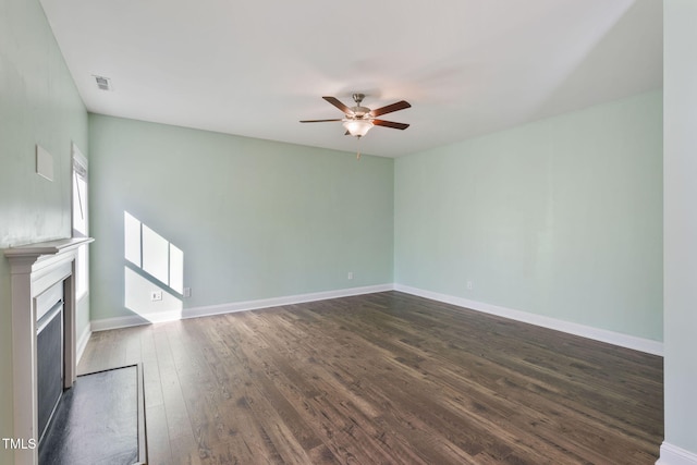 unfurnished living room featuring dark wood-type flooring, a fireplace, a ceiling fan, visible vents, and baseboards