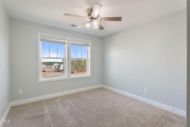 carpeted empty room with visible vents, baseboards, and a ceiling fan