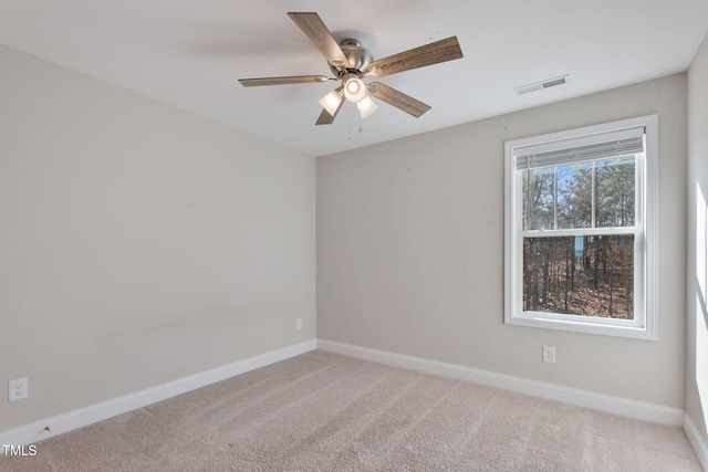 unfurnished room with light carpet, visible vents, baseboards, and a ceiling fan