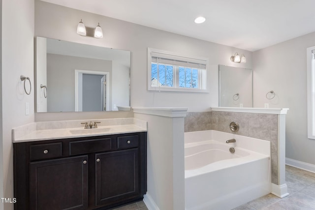 full bathroom featuring tile patterned flooring, a garden tub, vanity, and baseboards