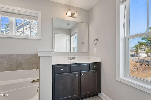 full bathroom featuring a bath, vanity, and baseboards