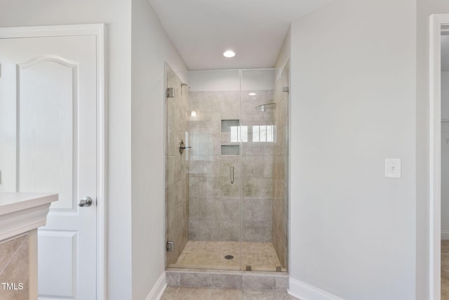 bathroom with a stall shower and baseboards