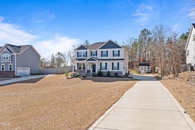 view of front of property featuring concrete driveway, covered porch, an attached garage, fence, and a shed