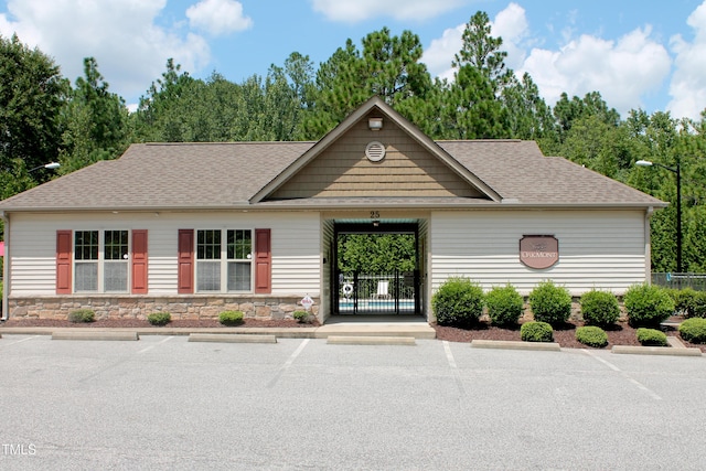 view of building exterior featuring uncovered parking and fence