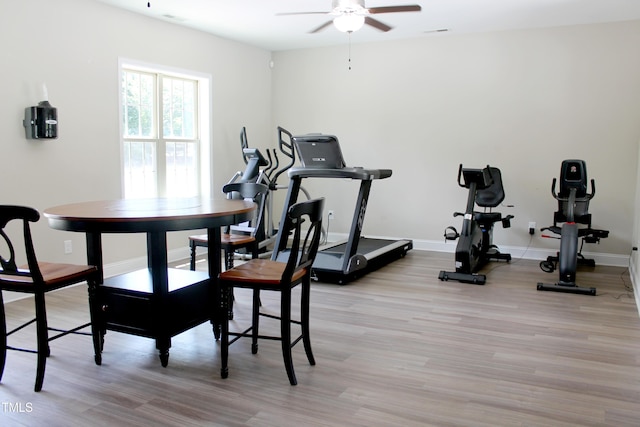 workout room with ceiling fan, light wood-style flooring, and baseboards