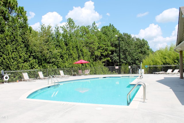 community pool with fence and a patio