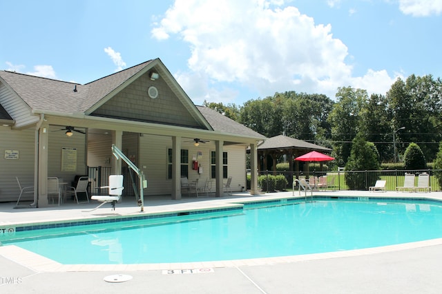 community pool featuring a ceiling fan, fence, and a patio