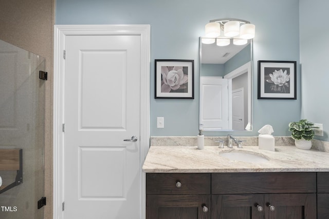 bathroom with vanity and a shower with door