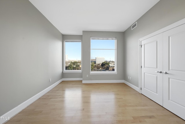 unfurnished bedroom with light hardwood / wood-style floors and a closet