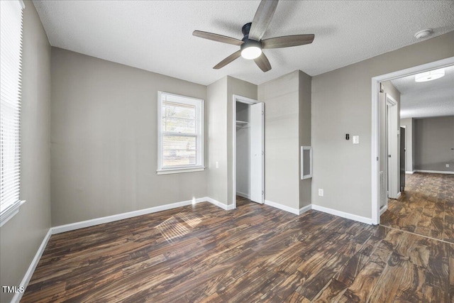 unfurnished bedroom featuring a closet, dark hardwood / wood-style floors, a textured ceiling, and ceiling fan