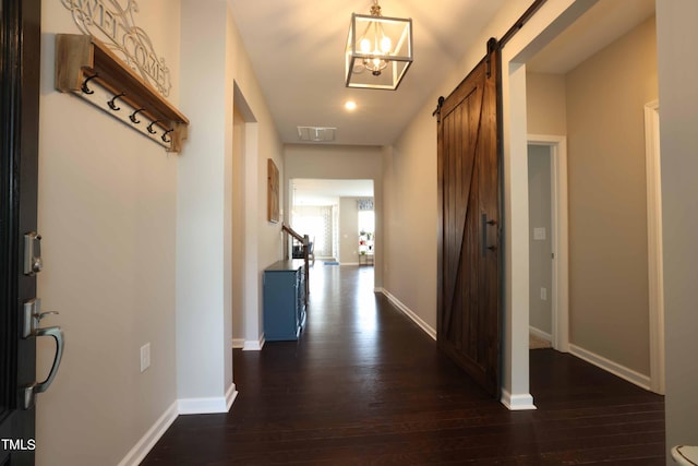 hall featuring a barn door and dark wood-type flooring