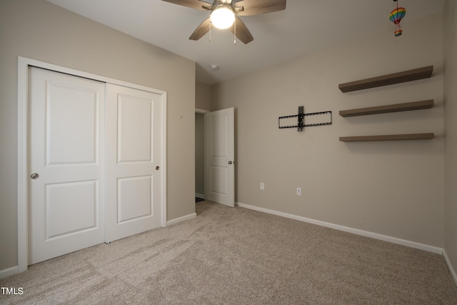 unfurnished bedroom with light colored carpet, ceiling fan, and a closet