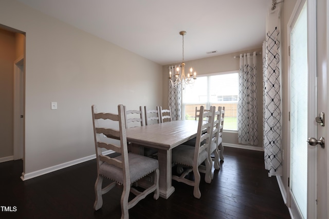 dining area featuring dark hardwood / wood-style flooring and an inviting chandelier