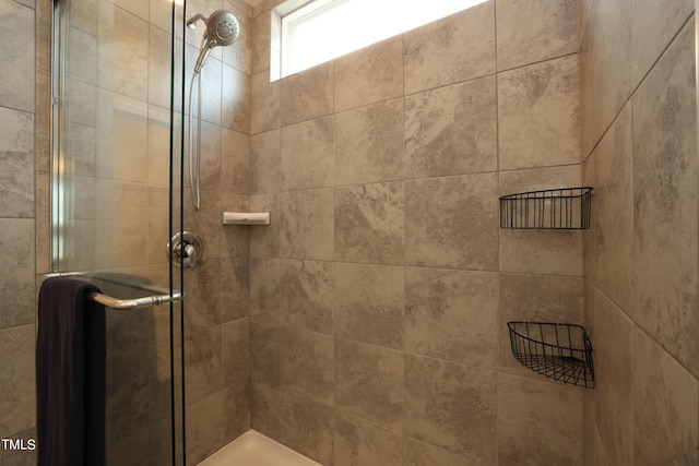 bathroom featuring a shower with shower door