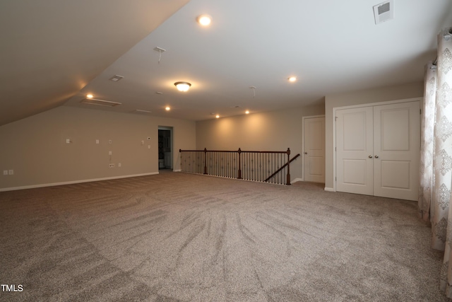 carpeted spare room with lofted ceiling