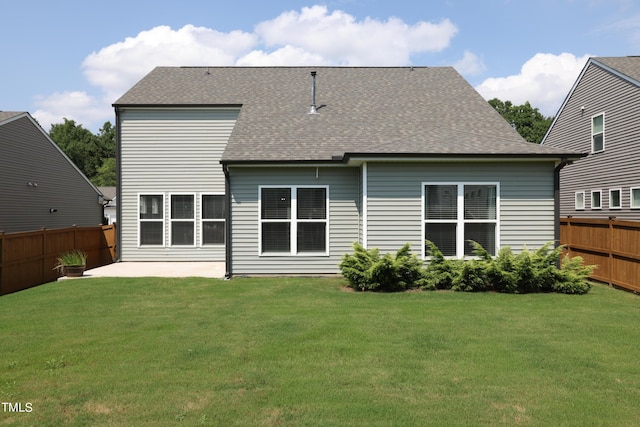 rear view of house with a yard and a patio