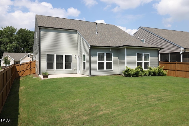 rear view of house with a yard and a patio