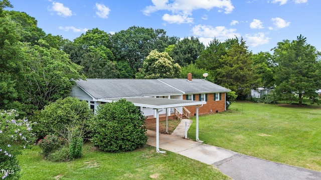 view of front of home with a carport and a front lawn