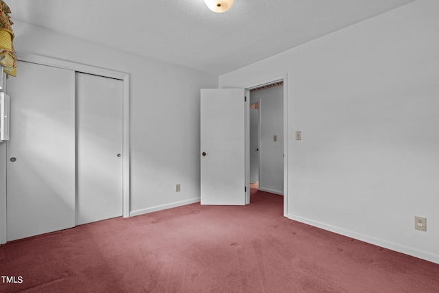 unfurnished bedroom featuring a closet, a textured ceiling, and carpet