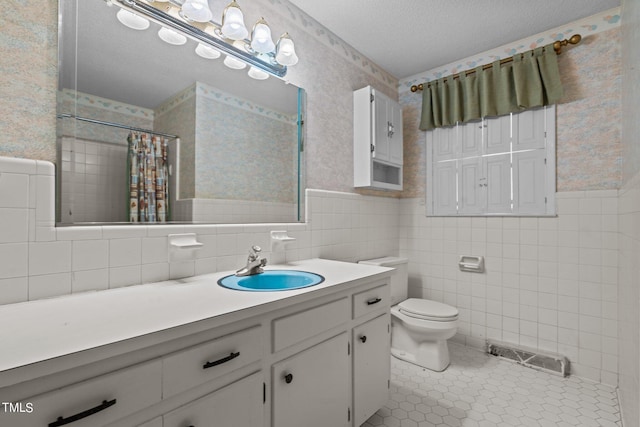 bathroom featuring vanity, a textured ceiling, tile patterned floors, toilet, and walk in shower