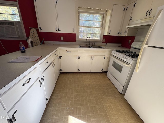 kitchen featuring white cabinetry, sink, cooling unit, and white appliances