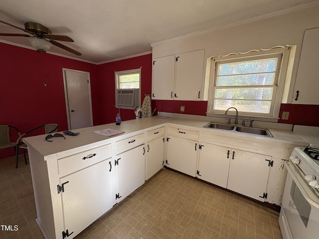 kitchen with sink, ornamental molding, white range with gas cooktop, kitchen peninsula, and white cabinets