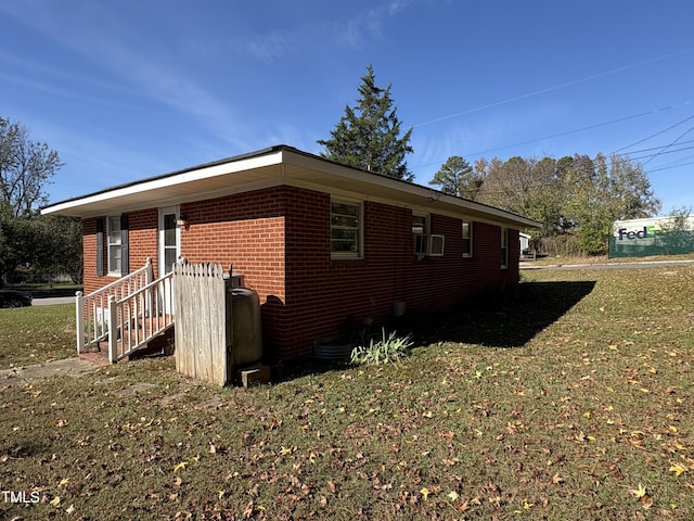 view of side of home with cooling unit and a lawn