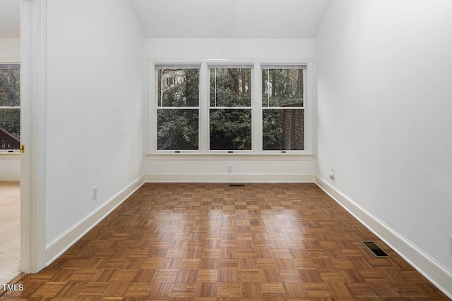 spare room featuring visible vents and baseboards