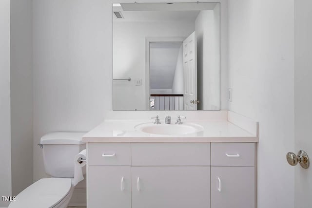 half bathroom featuring visible vents, toilet, and vanity