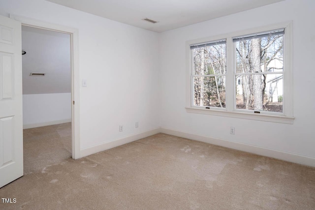 carpeted spare room featuring a wealth of natural light, visible vents, and baseboards