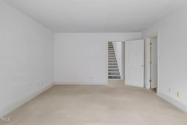 unfurnished room featuring baseboards and stairs