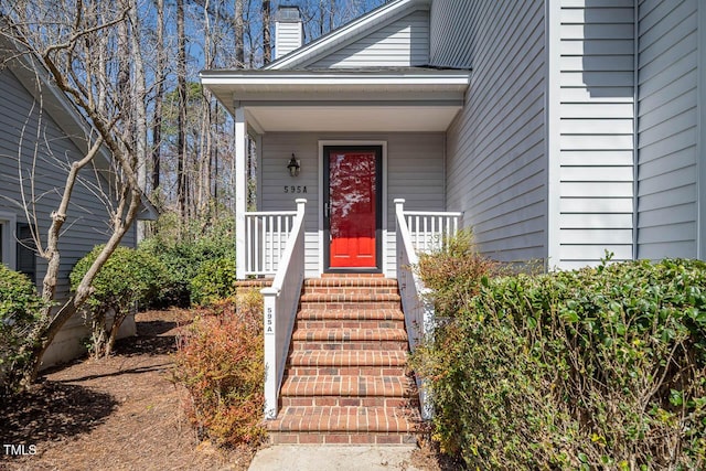 property entrance with covered porch and a chimney