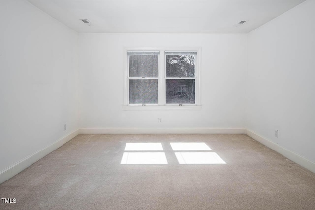 carpeted spare room featuring baseboards