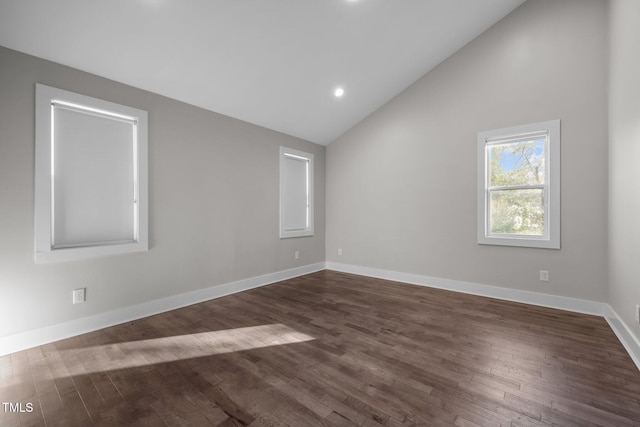 empty room with dark wood-type flooring and high vaulted ceiling