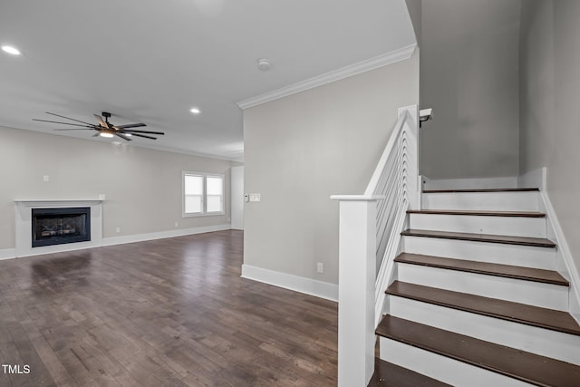 stairway featuring hardwood / wood-style floors, crown molding, and ceiling fan