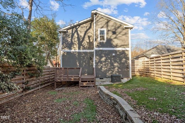 back of property featuring a deck and a lawn