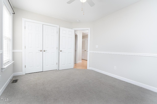 unfurnished bedroom featuring light carpet, ceiling fan, and a closet