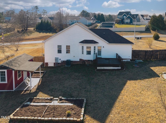 back of property featuring a storage unit, a deck, a lawn, and central air condition unit