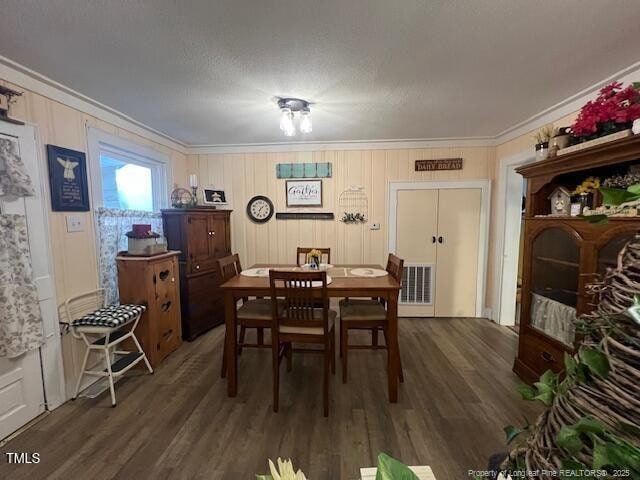 dining space featuring crown molding and dark hardwood / wood-style flooring