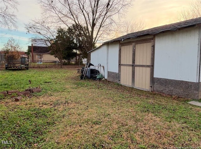 yard at dusk featuring a shed