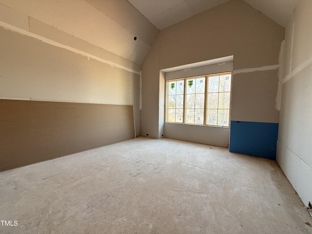 unfurnished room with lofted ceiling