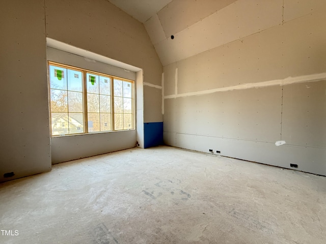 unfurnished room with vaulted ceiling