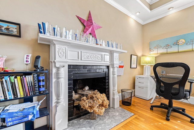 home office with crown molding, wood-type flooring, and a fireplace